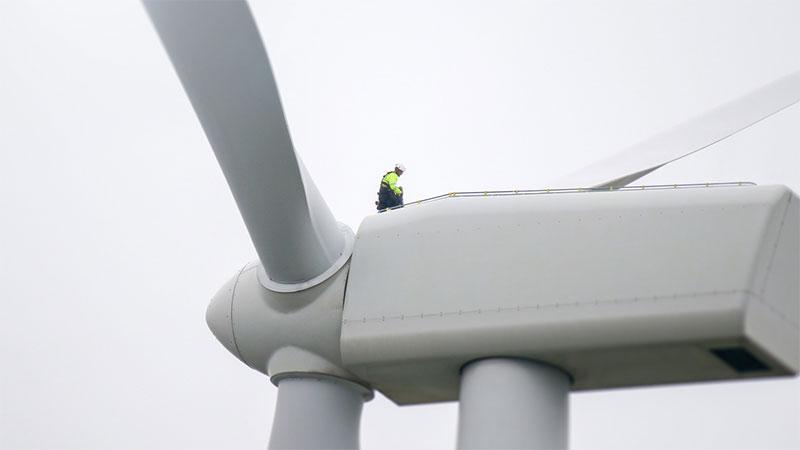 Installation worker on top of wind turbine